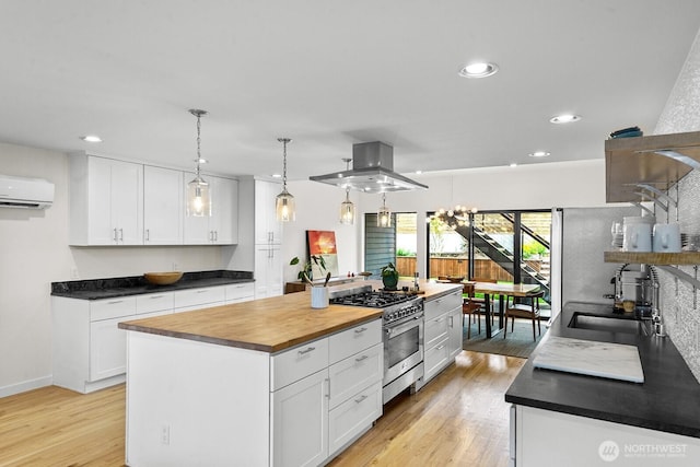 11017 Forest Ave S, Seattle, WA 98178 - kitchen with stainless steel stove, a wall mounted air conditioner, light wood finished floors, white cabinetry, and recessed lighting
