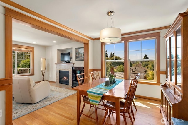 4415 40th Ave SW, Seattle, WA 98116 - dining space featuring a tiled fireplace, light wood finished floors, ornamental molding, and recessed lighting