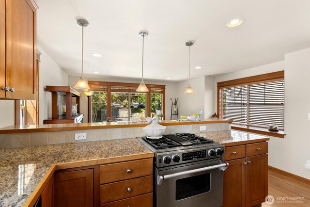 4415 40th Ave SW, Seattle, WA 98116 - kitchen featuring gas range, light wood finished floors, pendant lighting, brown cabinets, and recessed lighting
