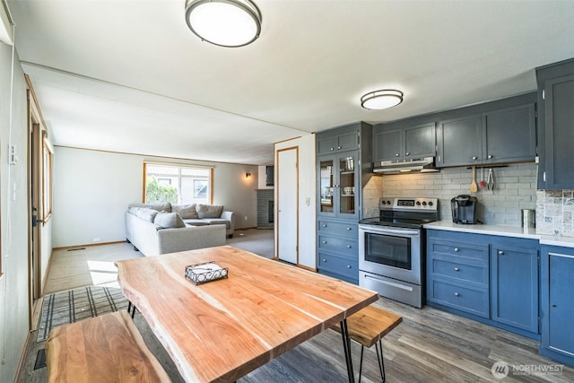 420 3rd St, Ronald, WA 98940 - kitchen with stainless steel range with electric cooktop, under cabinet range hood, wood finished floors, backsplash, and light countertops