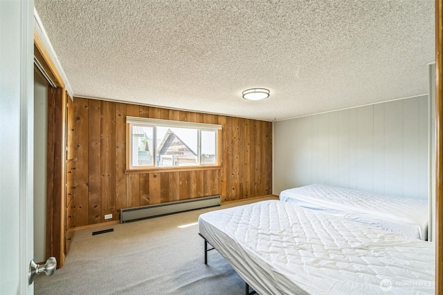 420 3rd St, Ronald, WA 98940 - carpeted bedroom featuring a baseboard heating unit, wood walls, a closet, and a textured ceiling