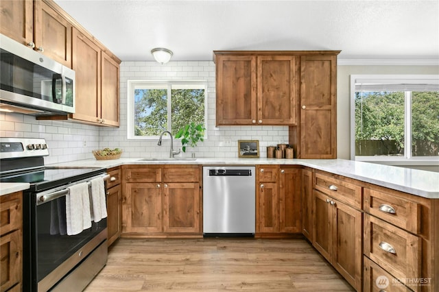 889 SW Kingma Ct, Oak Harbor, WA 98277 - kitchen with appliances with stainless steel finishes, a peninsula, light countertops, tasteful backsplash, and ornamental molding