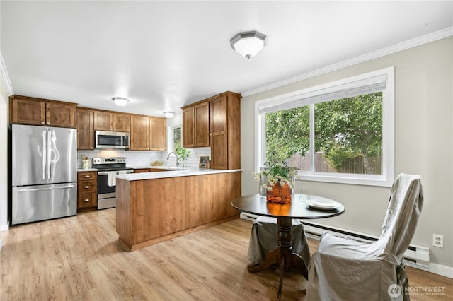 889 SW Kingma Ct, Oak Harbor, WA 98277 - kitchen featuring stainless steel appliances, a peninsula, ornamental molding, backsplash, and light countertops