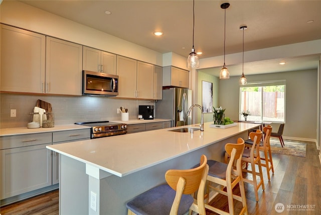 2014 101st Ave SE Unit 6, Lake Stevens, WA 98258 - kitchen with stainless steel appliances, gray cabinetry, dark wood finished floors, backsplash, and a center island with sink