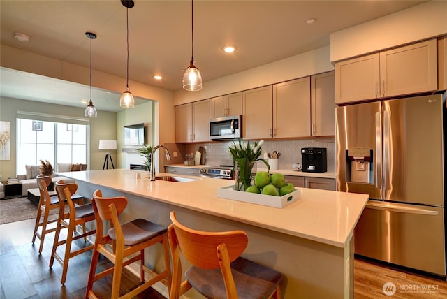 2014 101st Ave SE Unit 6, Lake Stevens, WA 98258 - kitchen with stainless steel appliances, light wood-style floors, a breakfast bar, light countertops, and decorative backsplash