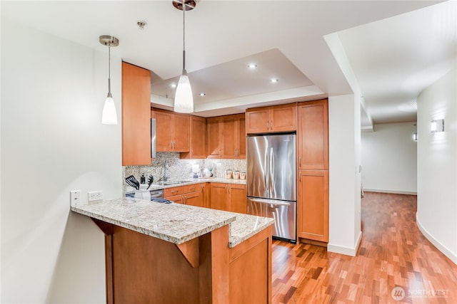 10650 NE 9th Pl Unit 3208, Bellevue, WA 98004 - kitchen with freestanding refrigerator, a peninsula, light wood finished floors, backsplash, and a tray ceiling