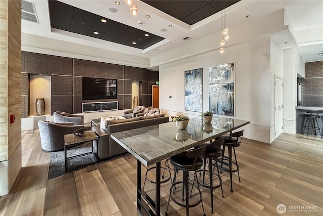 10650 NE 9th Pl Unit 3208, Bellevue, WA 98004 - kitchen featuring a raised ceiling, wood finished floors, recessed lighting, hanging light fixtures, and open floor plan