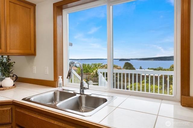 1021 N Sunset Dr, Camano Island, WA 98282 - kitchen featuring a water view, brown cabinetry, and tile counters