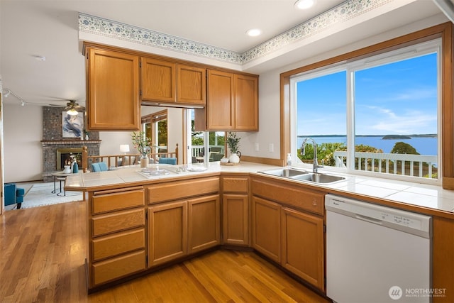 1021 N Sunset Dr, Camano Island, WA 98282 - kitchen featuring white appliances, tile countertops, a peninsula, light wood-style floors, and plenty of natural light