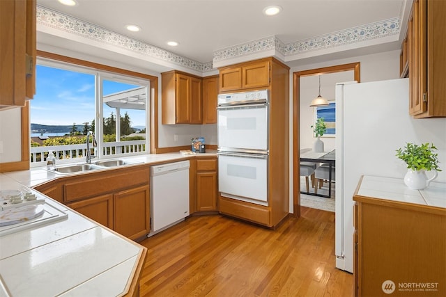 1021 N Sunset Dr, Camano Island, WA 98282 - kitchen featuring white appliances, light wood-type flooring, tile countertops, brown cabinetry, and recessed lighting