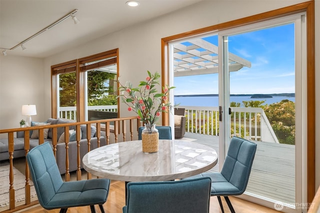 1021 N Sunset Dr, Camano Island, WA 98282 - dining space with a water view, rail lighting, wood finished floors, and recessed lighting