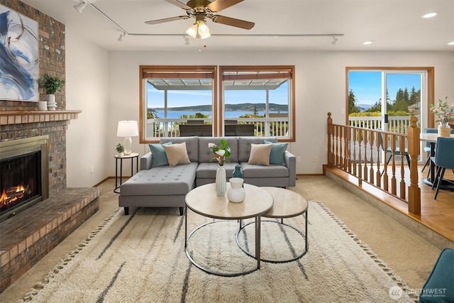 1021 N Sunset Dr, Camano Island, WA 98282 - carpeted living area with rail lighting, ceiling fan, a brick fireplace, plenty of natural light, and recessed lighting