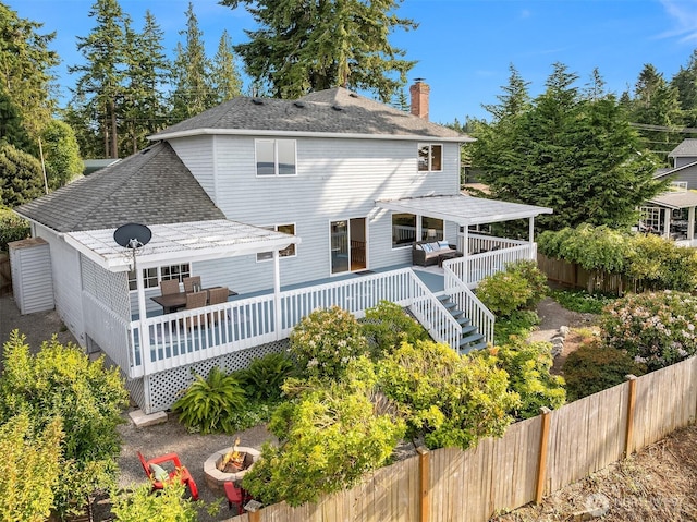 1021 N Sunset Dr, Camano Island, WA 98282 - rear view of house with an outdoor fire pit, roof with shingles, a chimney, and a wooden deck