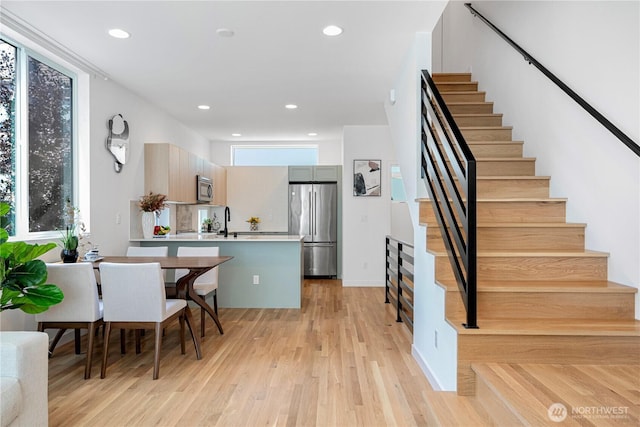 2620 NW 62nd St Unit B, Seattle, WA 98107 - kitchen with appliances with stainless steel finishes, light wood-style floors, light countertops, a peninsula, and recessed lighting