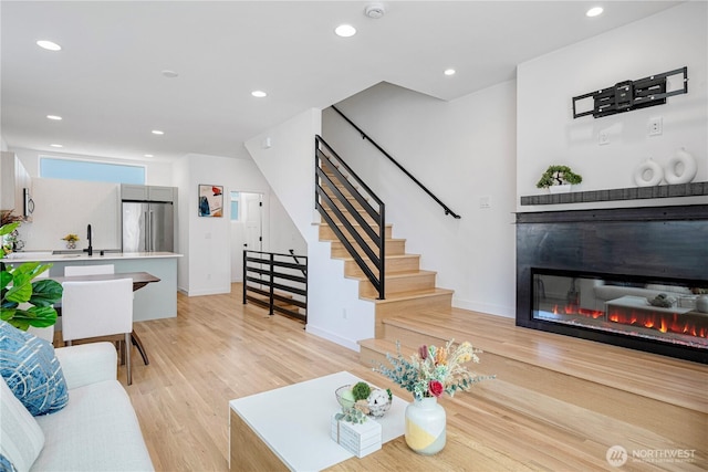 2620 NW 62nd St Unit B, Seattle, WA 98107 - living room with stairway, light wood finished floors, recessed lighting, and a glass covered fireplace
