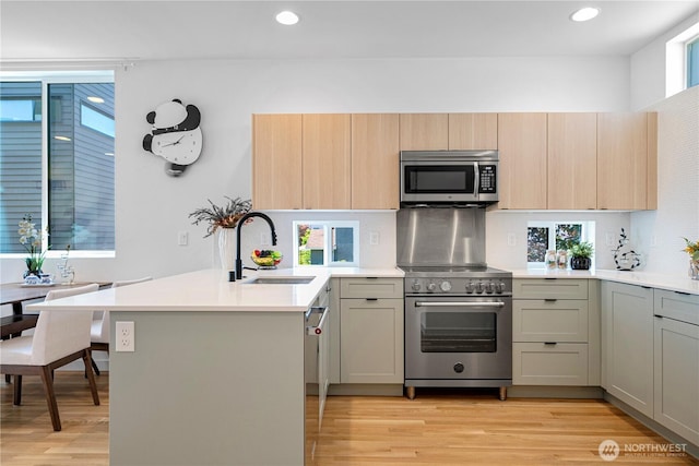 2620 NW 62nd St Unit B, Seattle, WA 98107 - kitchen featuring stainless steel appliances, a peninsula, recessed lighting, light countertops, and backsplash