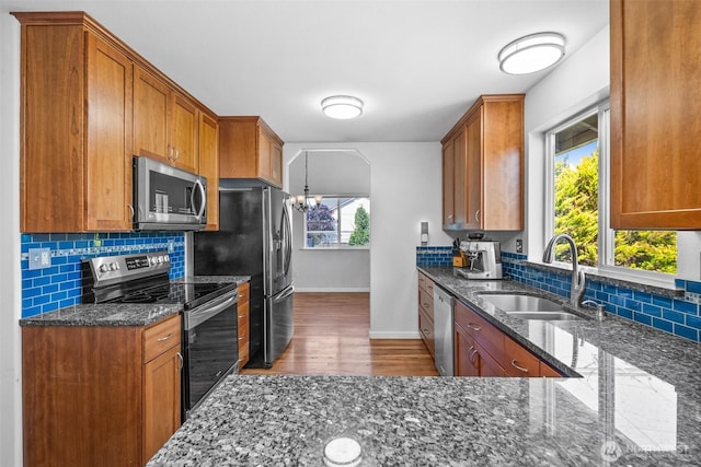 4509 224th Street Ct E, Spanaway, WA 98387 - kitchen with stainless steel appliances, brown cabinets, decorative backsplash, and dark stone countertops