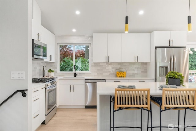 12804 NE 139th Ct, Kirkland, WA 98034 - kitchen featuring appliances with stainless steel finishes, light countertops, tasteful backsplash, white cabinets, and recessed lighting