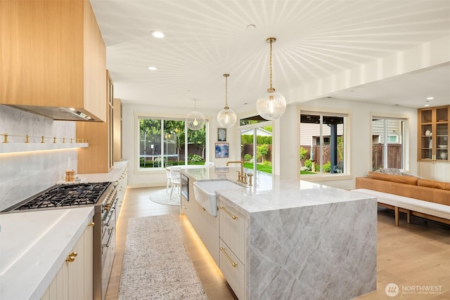 8411 202nd St SW, Edmonds, WA 98026 - kitchen featuring modern cabinets, recessed lighting, light wood-style floors, light stone countertops, and a large island