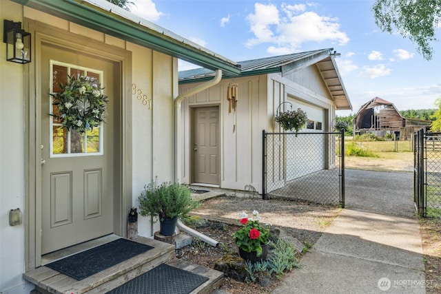 3381 Centralia Alpha Rd, Onalaska, WA 98570 - doorway to property with an attached garage, board and batten siding, a gate, and a metal roof