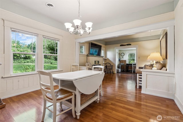 3381 Centralia Alpha Rd, Onalaska, WA 98570 - dining area with a fireplace, wood finished floors, and a chandelier