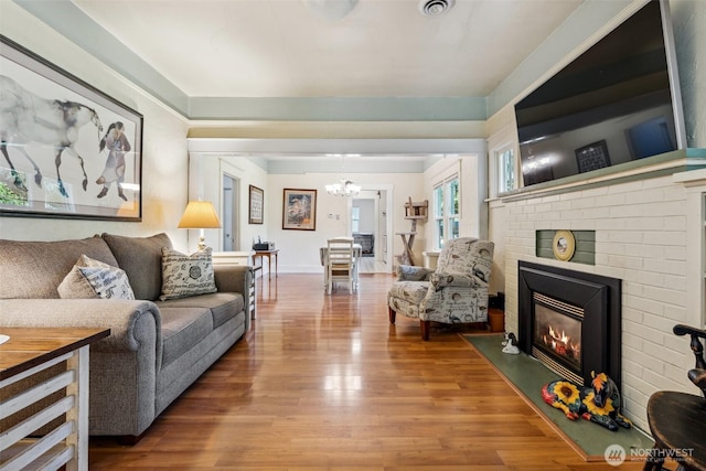 3381 Centralia Alpha Rd, Onalaska, WA 98570 - living room with a chandelier, wood finished floors, and a fireplace