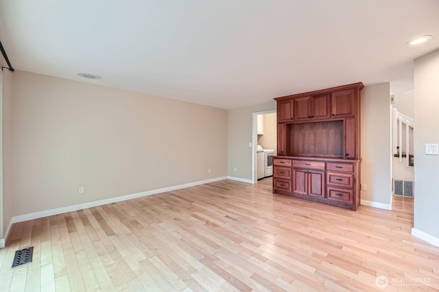 15831 Northup Way Unit 26, Bellevue, WA 98008 - unfurnished living room with light wood finished floors and washer / dryer