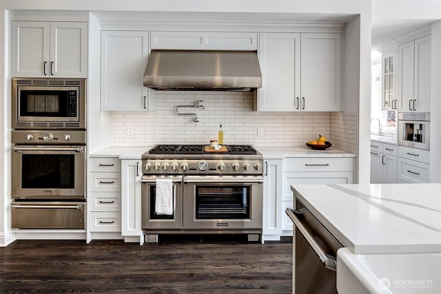 6581 156th Ave SE, Bellevue, WA 98006 - kitchen with appliances with stainless steel finishes, wall chimney exhaust hood, a warming drawer, and dark wood-style flooring