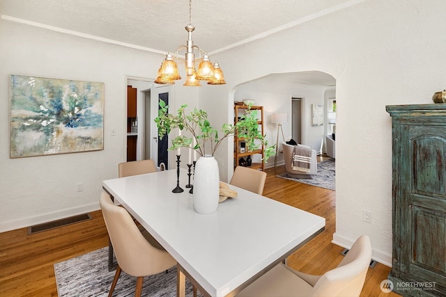 3112 NE 65th St, Seattle, WA 98115 - dining area with arched walkways, a chandelier, wood finished floors, and a textured ceiling
