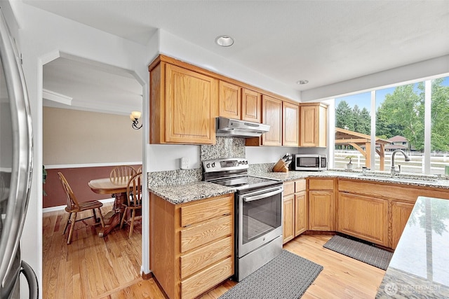 9321 339th St S Unit 5, Roy, WA 98580 - kitchen with stainless steel appliances, under cabinet range hood, light wood-style flooring, light stone countertops, and recessed lighting