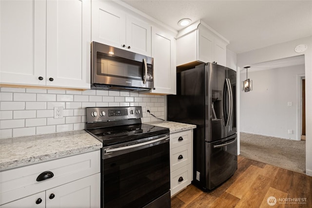 2220 91st St E, Tacoma, WA 98445 - kitchen with stainless steel appliances, white cabinets, wood finished floors, and tasteful backsplash