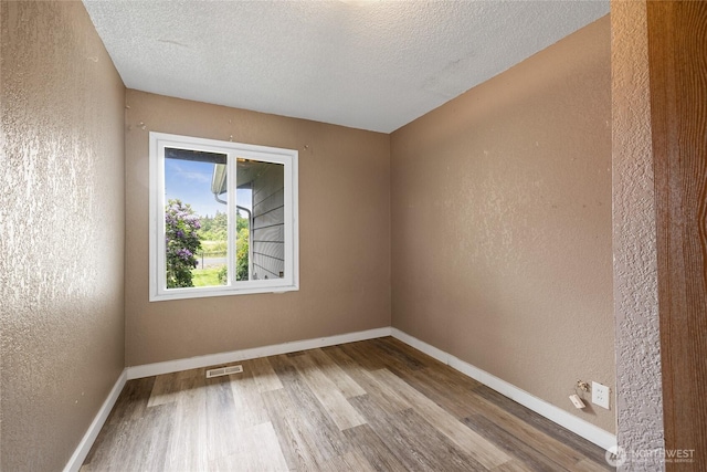 2220 91st St E, Tacoma, WA 98445 - spare room featuring wood finished floors, a textured wall, and a textured ceiling