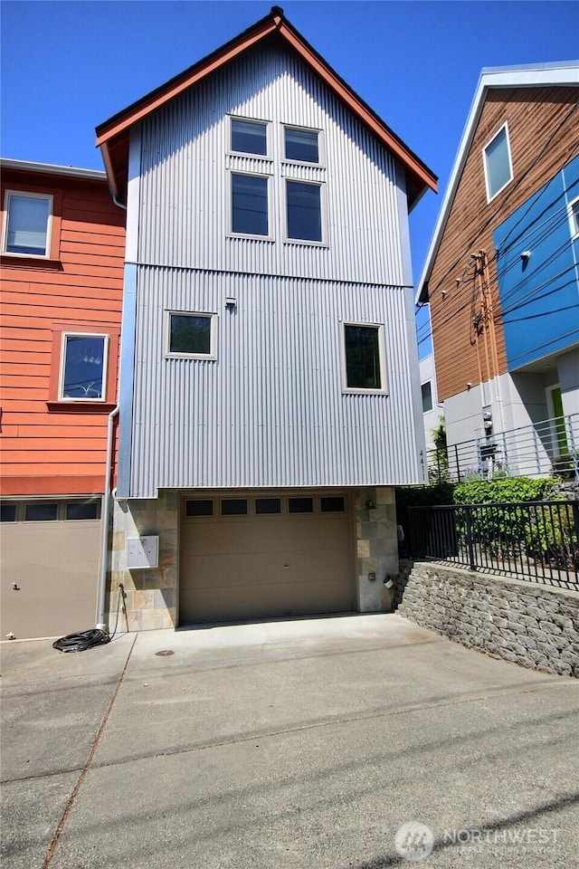 4411 Greenwood Ave N, Seattle, WA 98103 - view of front of home with stone siding, an attached garage, and driveway