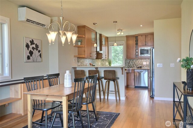 4411 Greenwood Ave N, Seattle, WA 98103 - dining room featuring a wall mounted AC, light wood-style flooring, a chandelier, and recessed lighting