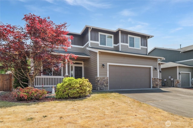 15309 91st Ave SE, Yelm, WA 98597 - view of front of home featuring a porch, an attached garage, board and batten siding, stone siding, and driveway
