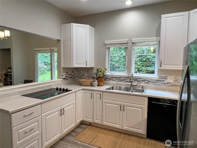 91 N Chandler Ct Unit D, Port Ludlow, WA 98365 - kitchen with black appliances, backsplash, white cabinetry, light countertops, and recessed lighting