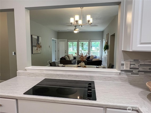 91 N Chandler Ct Unit D, Port Ludlow, WA 98365 - kitchen with black electric stovetop, a chandelier, white cabinetry, a ceiling fan, and light countertops