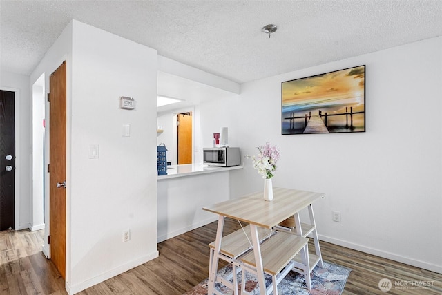 14760 NE 31st St Unit A307, Bellevue, WA 98007 - dining area with a textured ceiling and wood finished floors