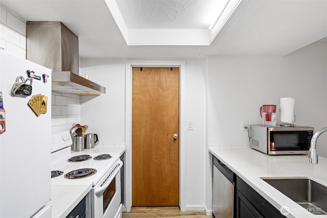 14760 NE 31st St Unit A307, Bellevue, WA 98007 - kitchen with appliances with stainless steel finishes, light wood-style floors, wall chimney range hood, dark cabinets, and tasteful backsplash