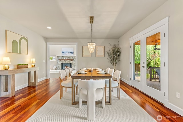 11028 E Riverside Dr, Bothell, WA 98011 - dining room featuring wood finished floors, a stone fireplace, recessed lighting, and a chandelier
