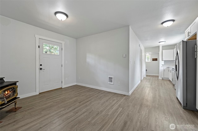 8471 Golden Valley Dr, Maple Falls, WA 98266 - foyer entrance with a wood stove, light wood-type flooring, healthy amount of natural light, and heating unit