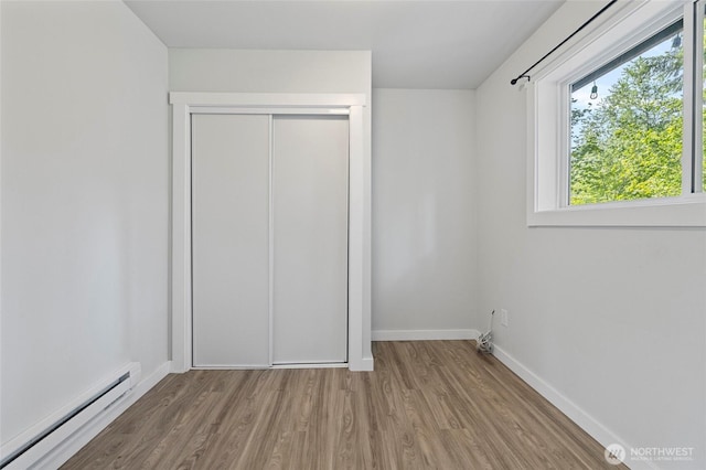 8471 Golden Valley Dr, Maple Falls, WA 98266 - unfurnished bedroom featuring a baseboard radiator, wood finished floors, and a closet
