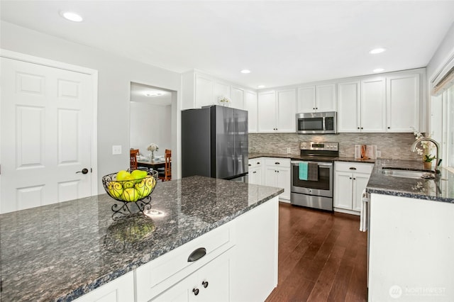 43712 SE 168th St, North Bend, WA 98045 - kitchen featuring appliances with stainless steel finishes, decorative backsplash, dark wood-type flooring, white cabinets, and dark stone countertops