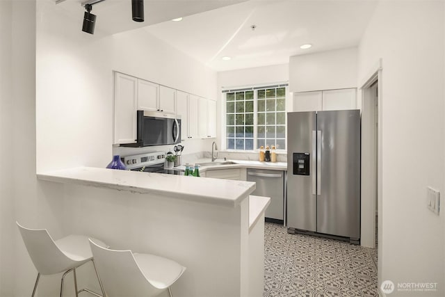 1900 132nd Ave SE Unit I-23, Bellevue, WA 98005 - kitchen with appliances with stainless steel finishes, light countertops, white cabinetry, a peninsula, and recessed lighting