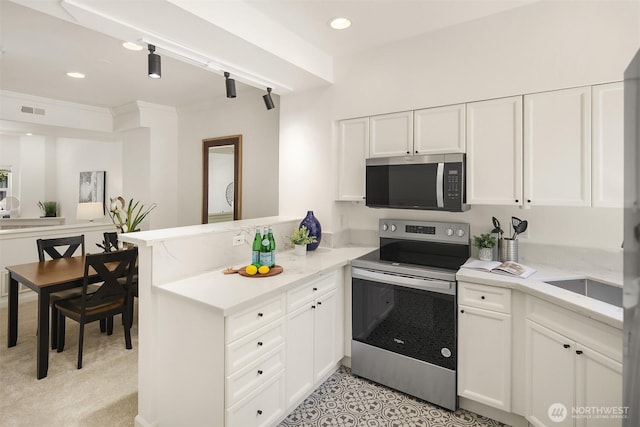 1900 132nd Ave SE Unit I-23, Bellevue, WA 98005 - kitchen featuring appliances with stainless steel finishes, a peninsula, white cabinetry, recessed lighting, and crown molding