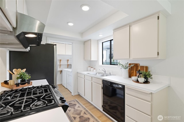 1708 24th Ct, Anacortes, WA 98221 - kitchen featuring black dishwasher, range with gas stovetop, separate washer and dryer, freestanding refrigerator, and exhaust hood