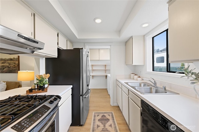 1708 24th Ct, Anacortes, WA 98221 - kitchen with extractor fan, appliances with stainless steel finishes, a tray ceiling, light countertops, and light wood-style floors