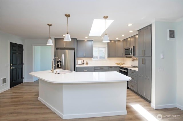 15512 Elm St E, Sumner, WA 98390 - kitchen with gray cabinets, stainless steel appliances, light wood-style floors, tasteful backsplash, and ornamental molding