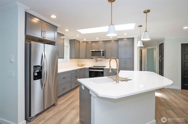 15512 Elm St E, Sumner, WA 98390 - kitchen featuring stainless steel appliances, gray cabinets, a skylight, decorative backsplash, and light wood-style flooring
