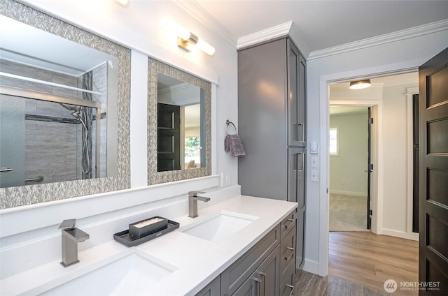 15512 Elm St E, Sumner, WA 98390 - bathroom featuring double vanity, crown molding, wood finished floors, and a tile shower